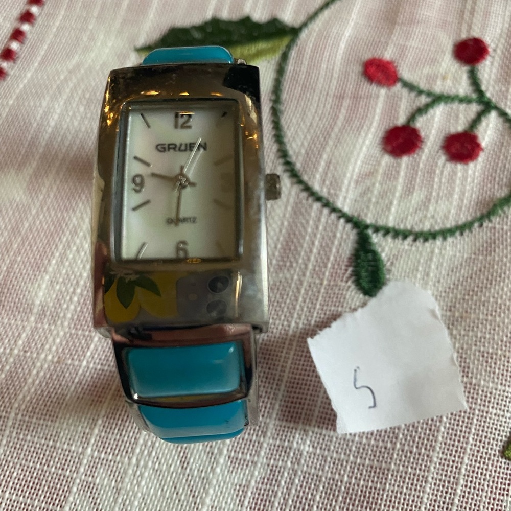 Gruen ladies cuff bangle watch. Mother of pearl face. Blue stone accent on cuff.